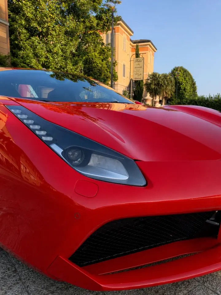 Dettaglio verticale di una Ferrari rossa davanti alla struttura